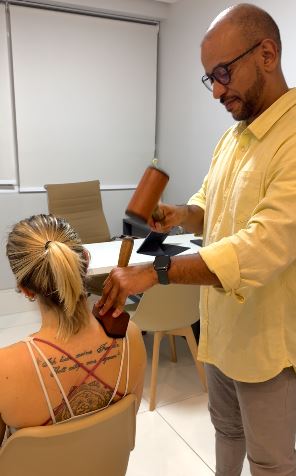 Aplicação com martelo de madeira em atendimento sentado